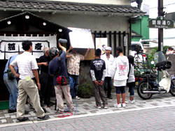 写真:お店の前で野島さんに取材交渉