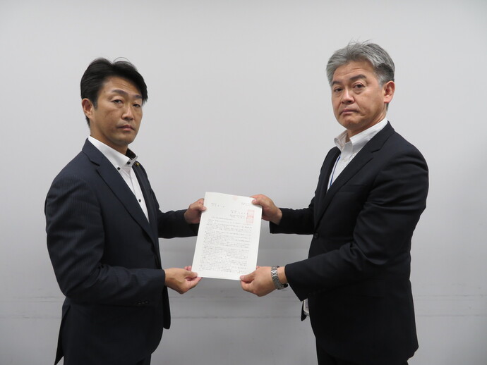 写真:佐藤横田基地対策特別委員長から深和防衛省地方協力統括調整官(東日本協力課長)へ要請