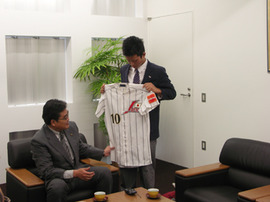 写真：日本代表のユニフォームを手に報告をする中嶋さん