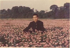 画像：学生時代に田園地域のレンゲの花に囲まれて（第5小学校付近）